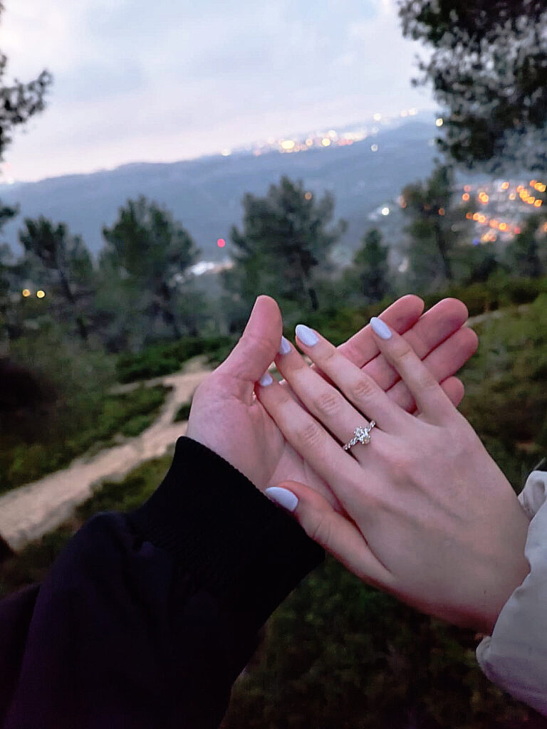 יד של אישה עם טבעת מונחת על יד של גבר